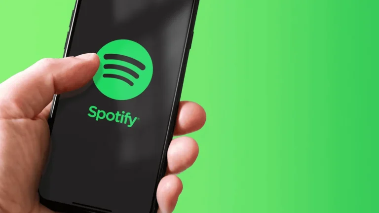 Ręka trzymająca smartfon z otwartą aplikacją Spotify na zielonym tle
